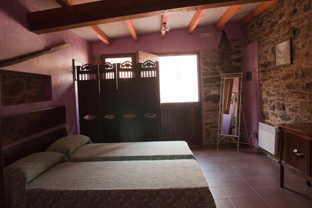 a bedroom with a bed in a room with purple walls at Calzada Romana in Cedeira
