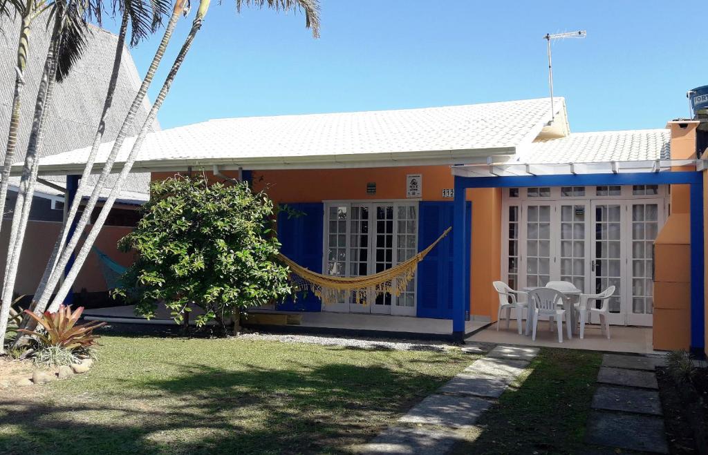 a house with a hammock in the front of it at Casa Praia da Pinheira a 50m praia in Pinheiro