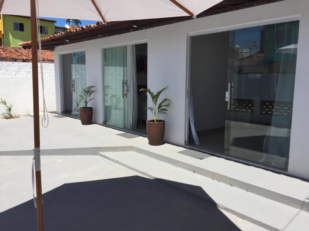 einen Balkon eines Hauses mit zwei Topfpflanzen in der Unterkunft Sorrento Suítes Maragogi a 3 min da Orla in Maragogi