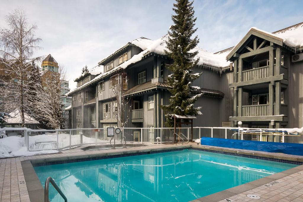 a house with a swimming pool in the snow at Glacier Lodge in Whistler