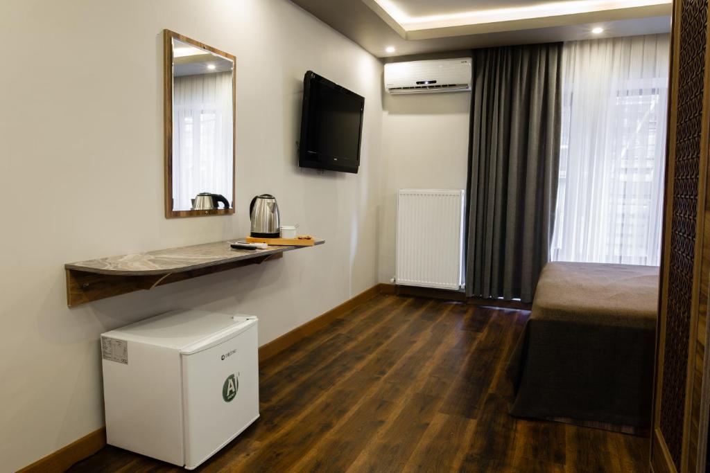 イスタンブールにあるタクシム ムードのベッド、洗面台、鏡が備わる客室です。