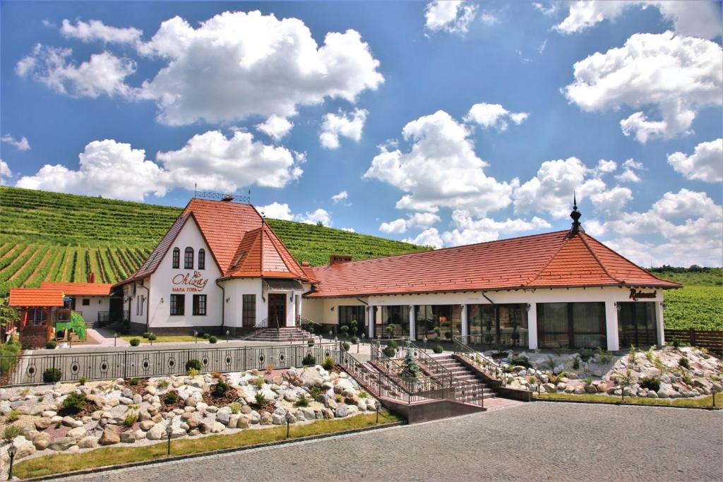 un bâtiment avec un toit orange dans un vignoble dans l'établissement Chizay. Мала Гора, à Berehove