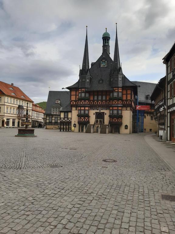 ein großes Gebäude mit einem Uhrturm auf einer Straße in der Unterkunft Ferienwohnung Holzmann in Wernigerode