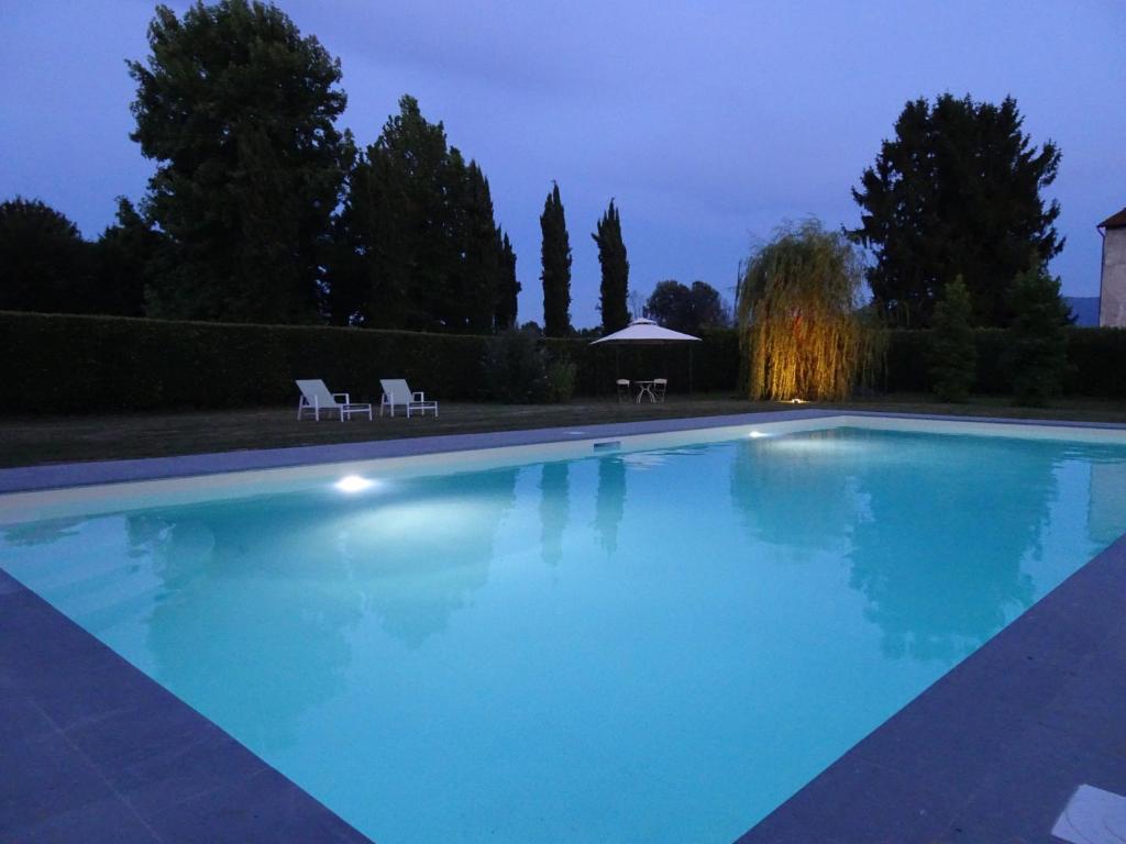 een groot blauw zwembad in een tuin 's nachts bij Il Nido in Lucca