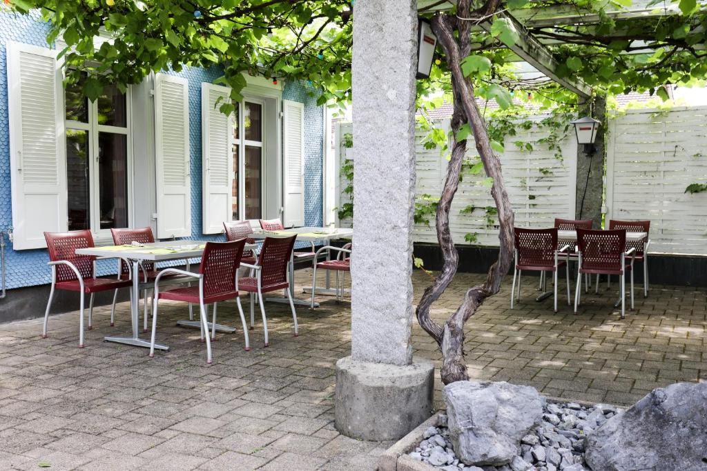 eine Gruppe von Stühlen und Tischen auf einer Terrasse in der Unterkunft hotel löwen in Niederuzwil