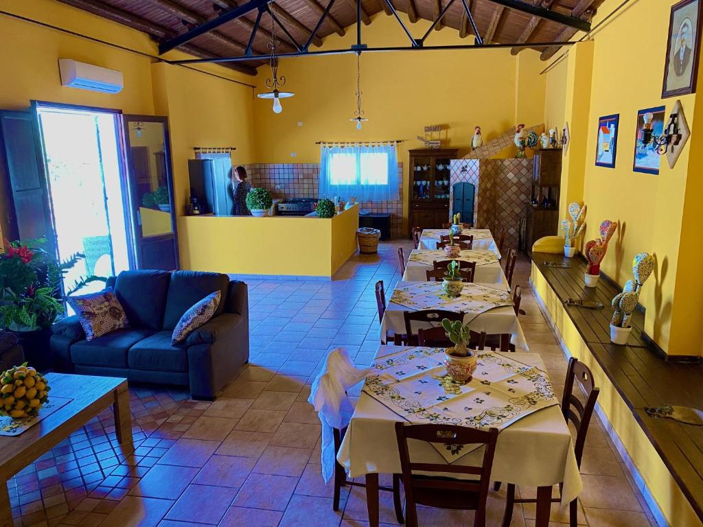 une salle à manger avec des tables et un canapé bleu dans l'établissement I Gelsomini, à Marinella di Selinunte