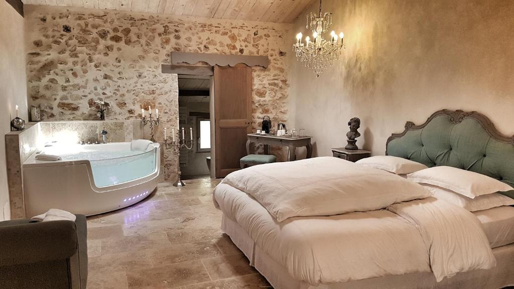 a bedroom with a bed and a bath tub at Le Domaine Saint Martin in Flassans-sur-Issole