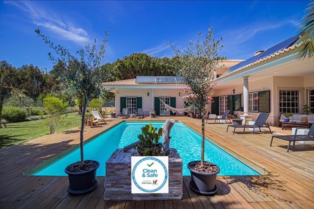 a house with a swimming pool with trees in the yard at Buganvilias Do Meco Guest house in Sesimbra