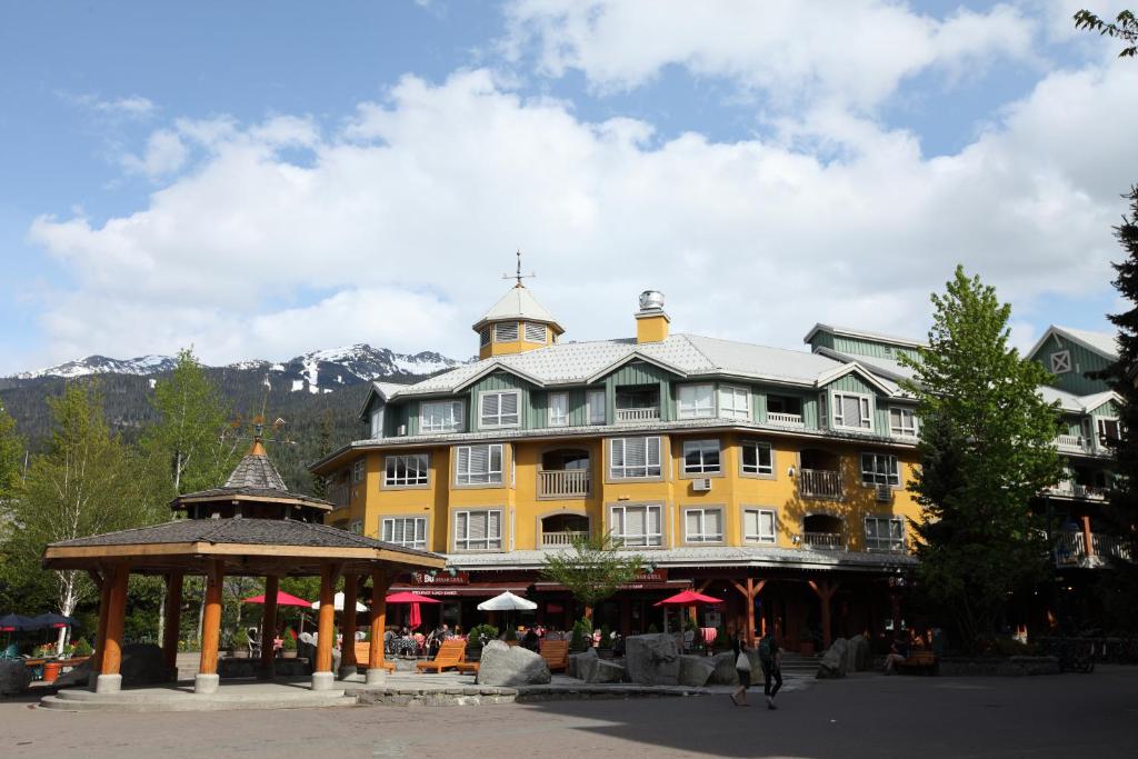 un gran edificio amarillo con un cenador frente a él en Town Plaza Suites, en Whistler