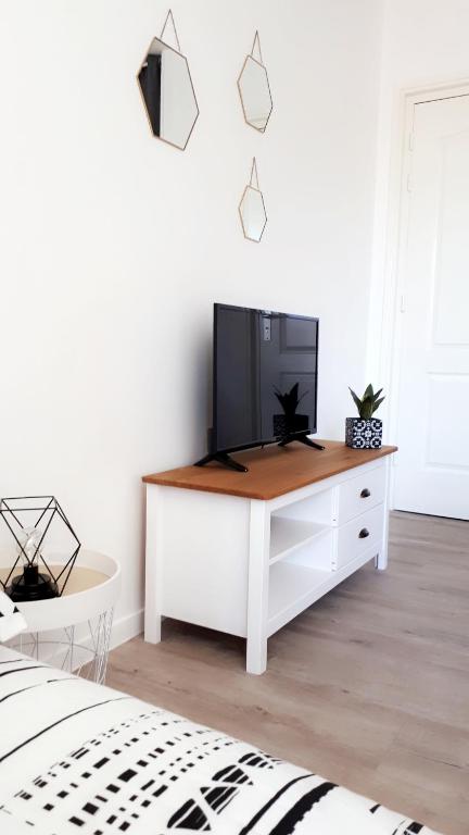 - une chambre dotée d'une armoire blanche et d'une télévision dans l'établissement STUDIO ENTRE PLAGE ET PORT, à Les Sables-dʼOlonne