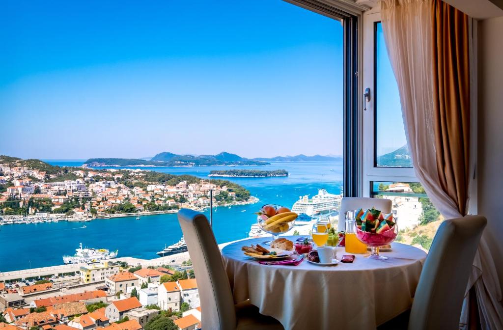 
a dining room table with a view of the ocean at Apartments Dilberovic in Dubrovnik
