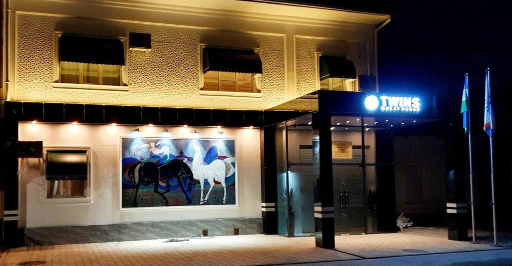 a building with a painting of horses on the side of it at Guest house TWINS in Tashkent