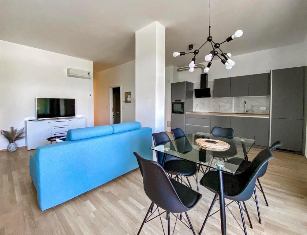 ein Wohnzimmer mit einem blauen Sofa und einem Glastisch in der Unterkunft Seaview Apt Koper 1 in Koper