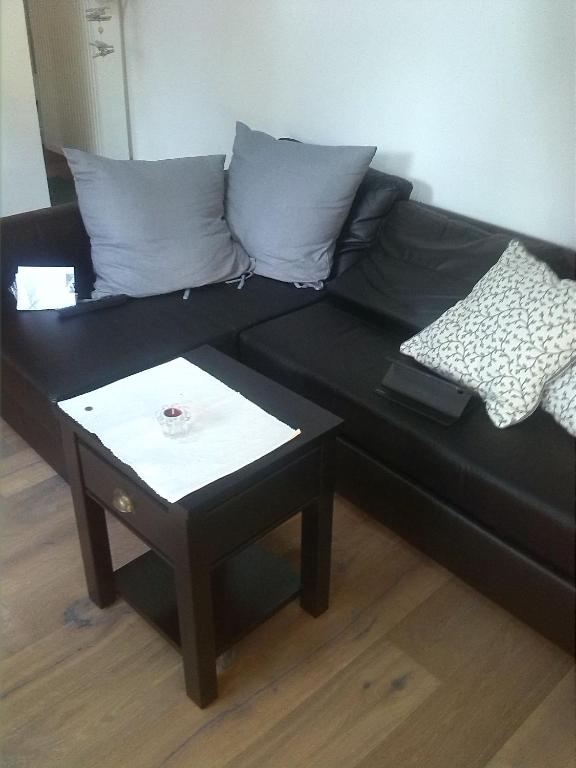 a black couch with two pillows and a table at Echt Ostfriesenhus in Norden