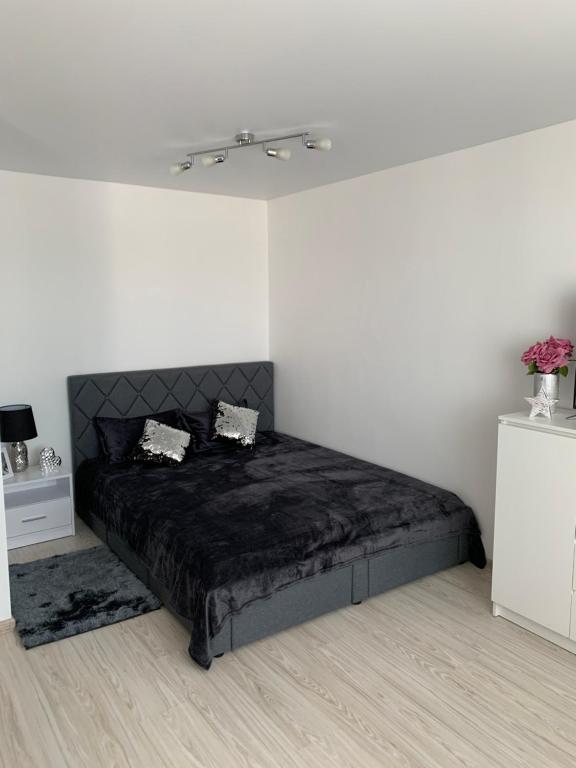 ein Schlafzimmer mit einem schwarzen Bett in einem weißen Zimmer in der Unterkunft Apartment in Palanga in Palanga
