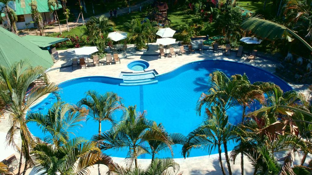 an overhead view of a large blue swimming pool with palm trees at Hotel Villas Rio Mar in Dominical