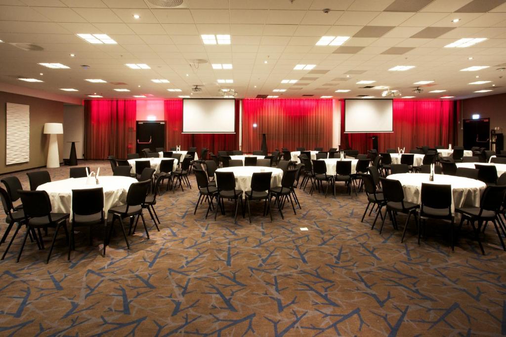 una sala banchetti con tavoli, sedie e tende rosse di Clarion Hotel Sense a Luleå