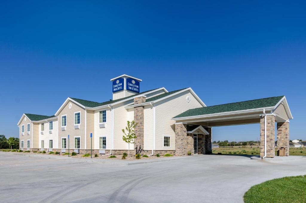 a large white building with a clock tower on top at Cobblestone Inn & Suites Cambridge in Cambridge