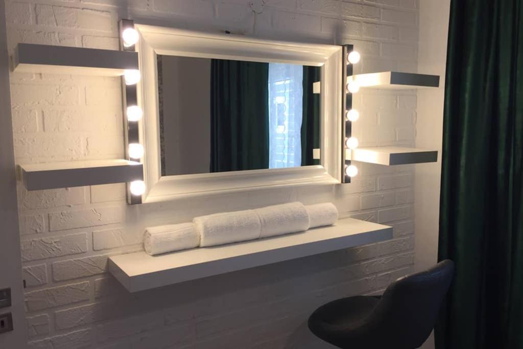 ein Badezimmer mit einem Spiegel und einem Regal mit Handtüchern in der Unterkunft Cosy holiday apartment in Lagos in Lagos