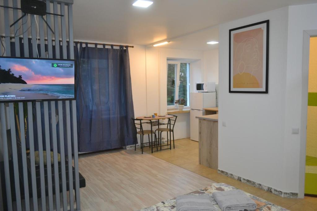ein Wohnzimmer mit einem Flachbild-TV und eine Küche in der Unterkunft Smart in Ternopil