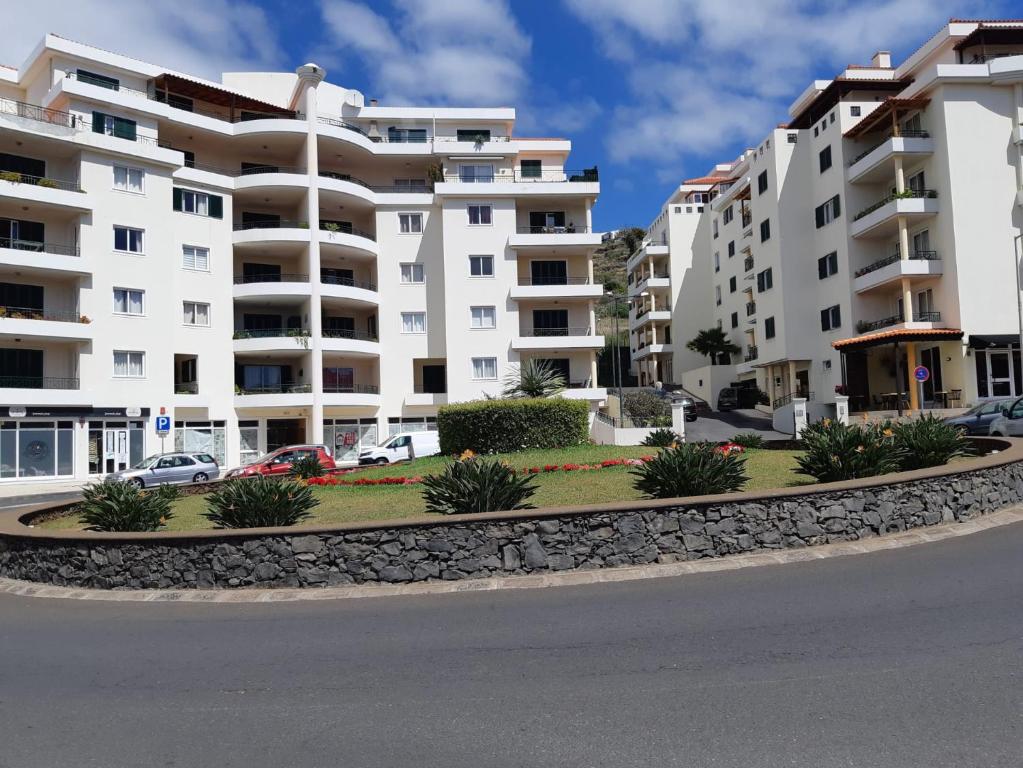 uma fila de edifícios de apartamentos brancos com uma rua em Apartamento Marques em Santa Cruz - Madeira