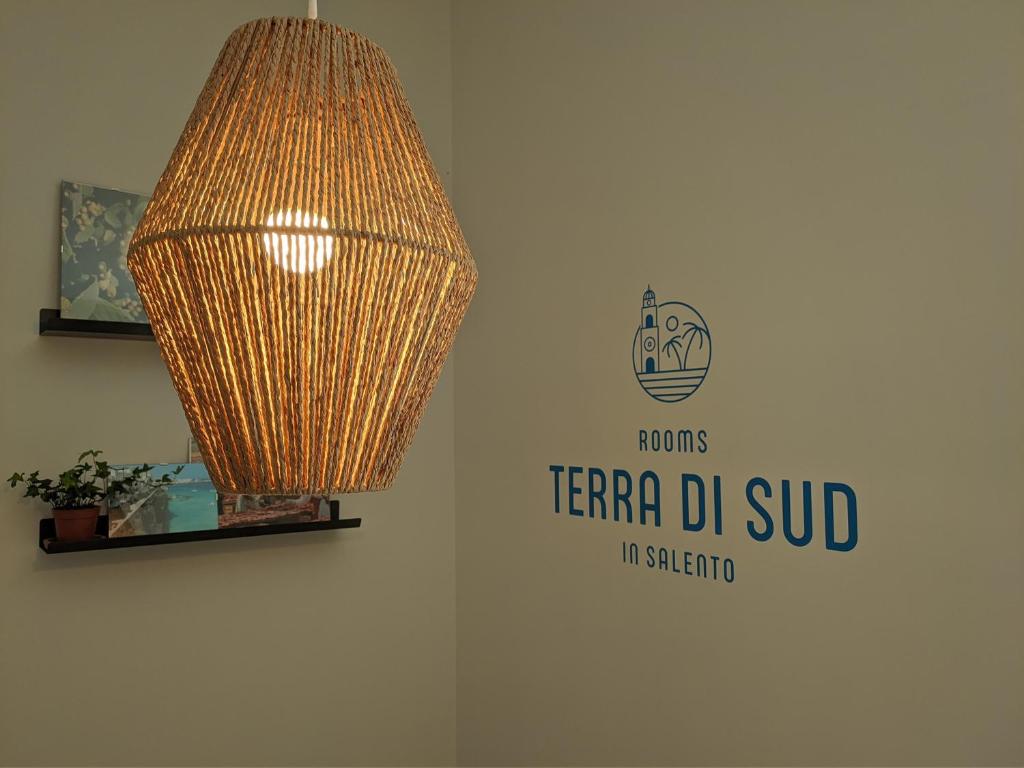 een licht hangend aan een muur naast een bord bij Terra di Sud Rooms in Lecce