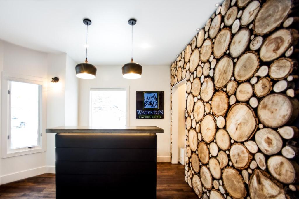 un mur en rondins dans une cuisine avec deux lampes pendant dans l'établissement Waterton Glacier Suites, à Waterton Park