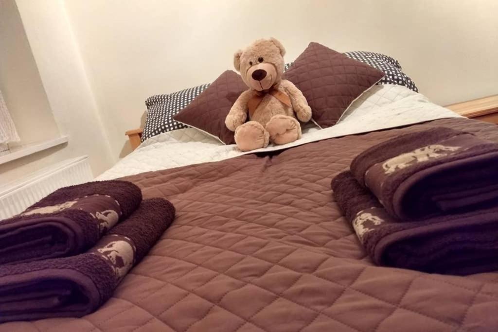 a teddy bear sitting on top of a bed at Apartament White Biały Dunajec in Biały Dunajec