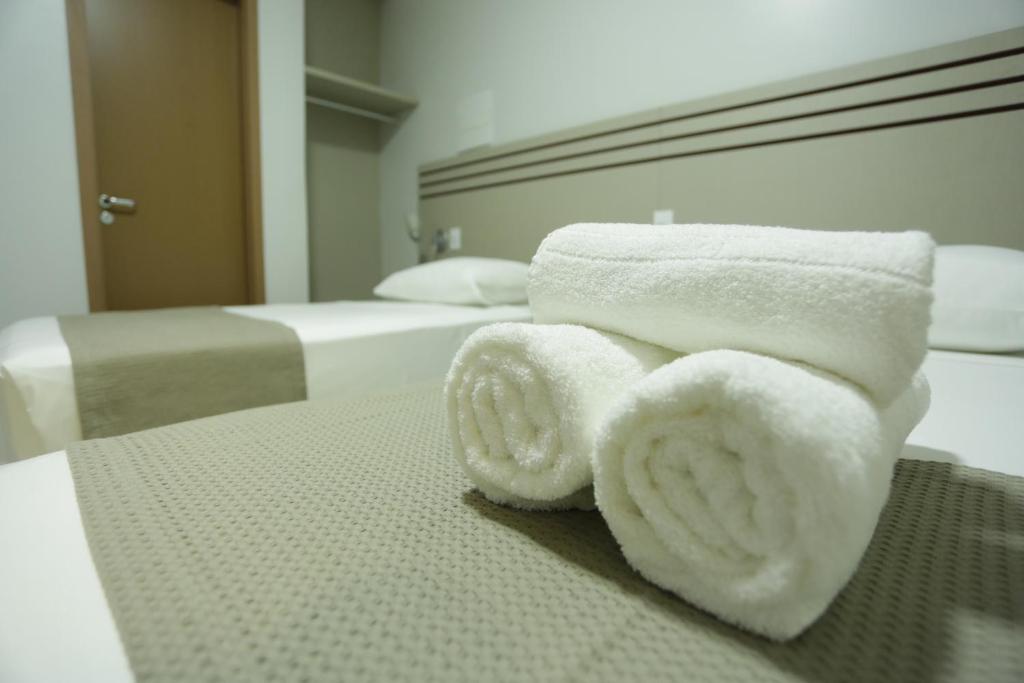 un mucchio di asciugamani seduti sopra un letto di Valen Porto Hotel São Luís a São Luís