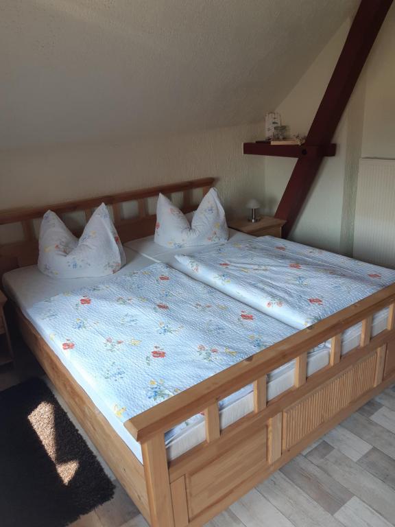 a bed with a wooden frame and pillows on it at Spreewaldpension Glatz in Müschen