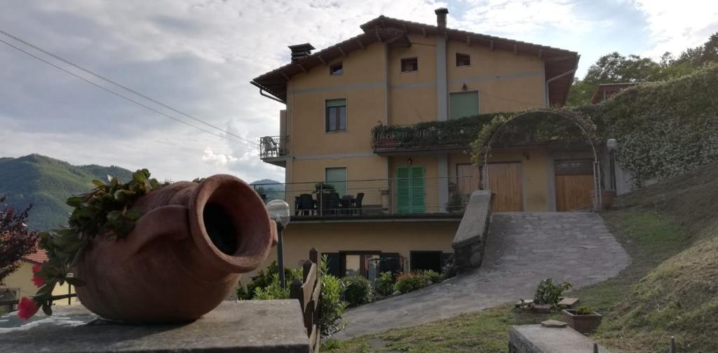 una gran olla sentada frente a una casa en La Tana di Brocciolino, en Popiglio