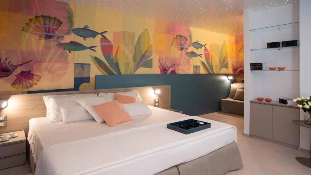 a bedroom with a large bed with a painting on the wall at Hotel President in Lignano Sabbiadoro