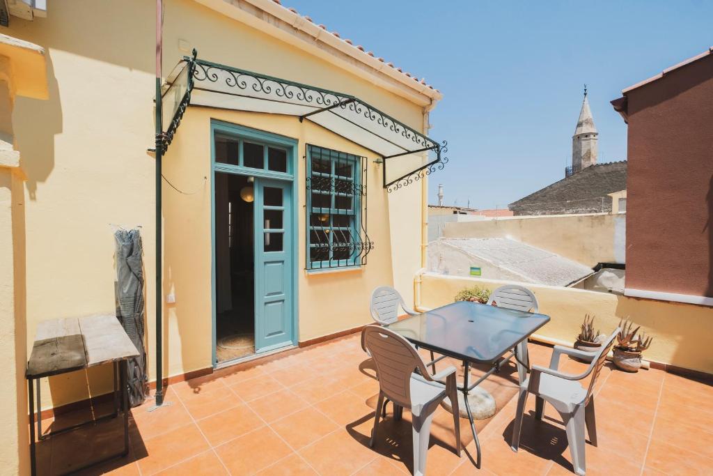 eine Terrasse mit einem Tisch, Stühlen und einer blauen Tür in der Unterkunft Home with Terrace in Heart of old Town of Chania in Chania