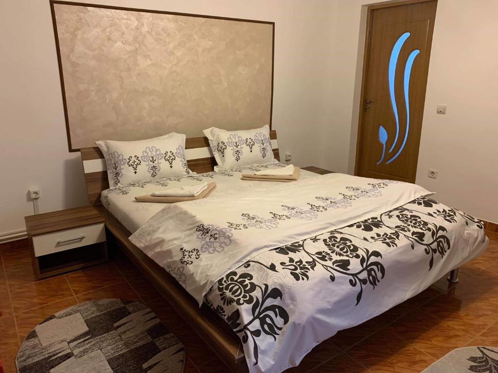 - une chambre avec un lit et une couette noire et blanche dans l'établissement Casa Madalina, à Săpînţa