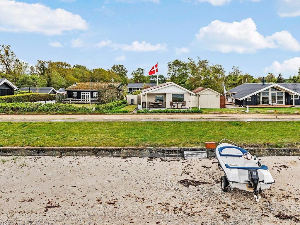 un barco sentado en la arena frente a las casas en 6 person holiday home in Otterup, en Otterup