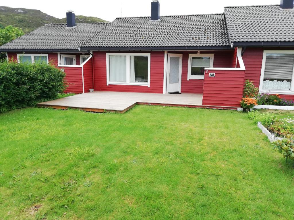 uma casa vermelha com um relvado à frente em Leinastova em Sandshamn