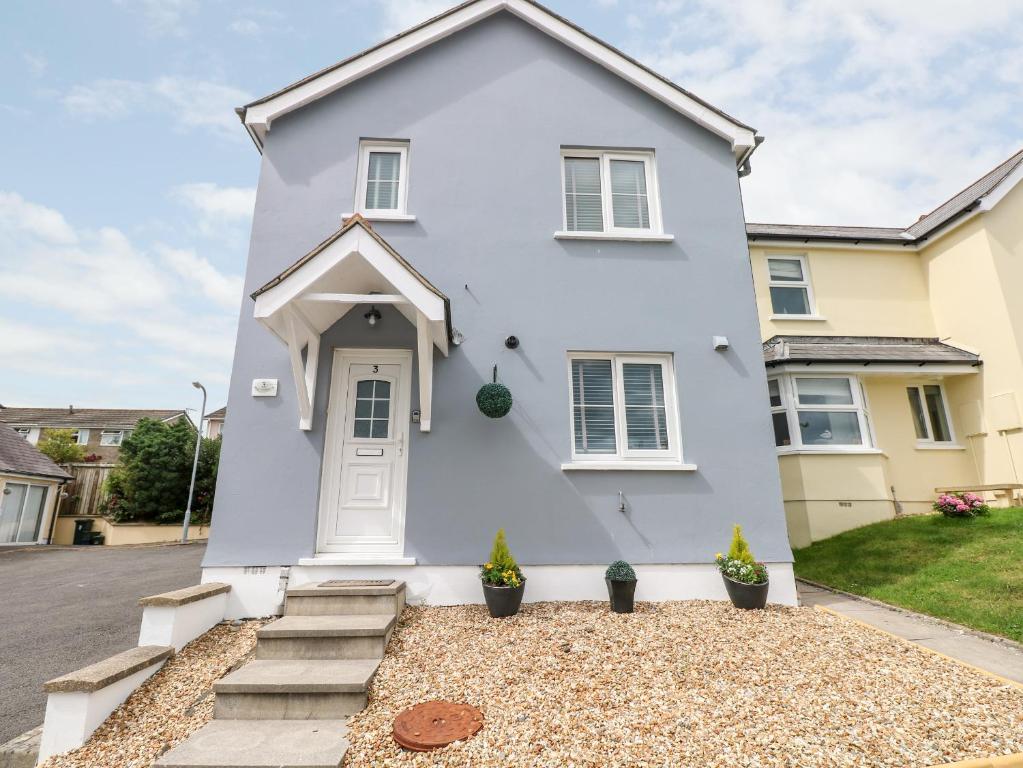 a white house with a white door at Sandy Bay House in Saundersfoot