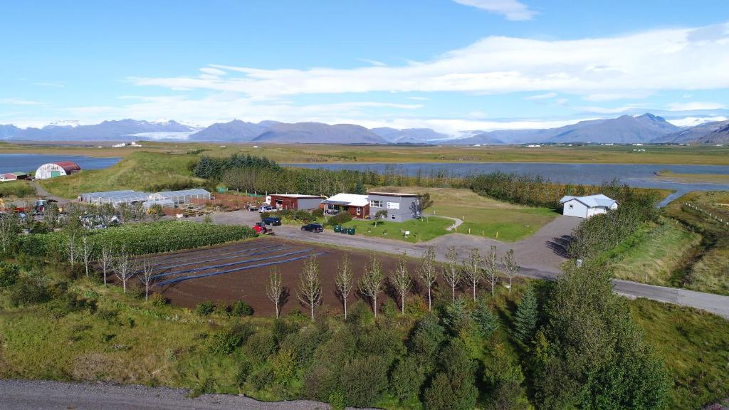 an aerial view of a farm with a lake and mountains at Dilksnes Guesthouse in Höfn