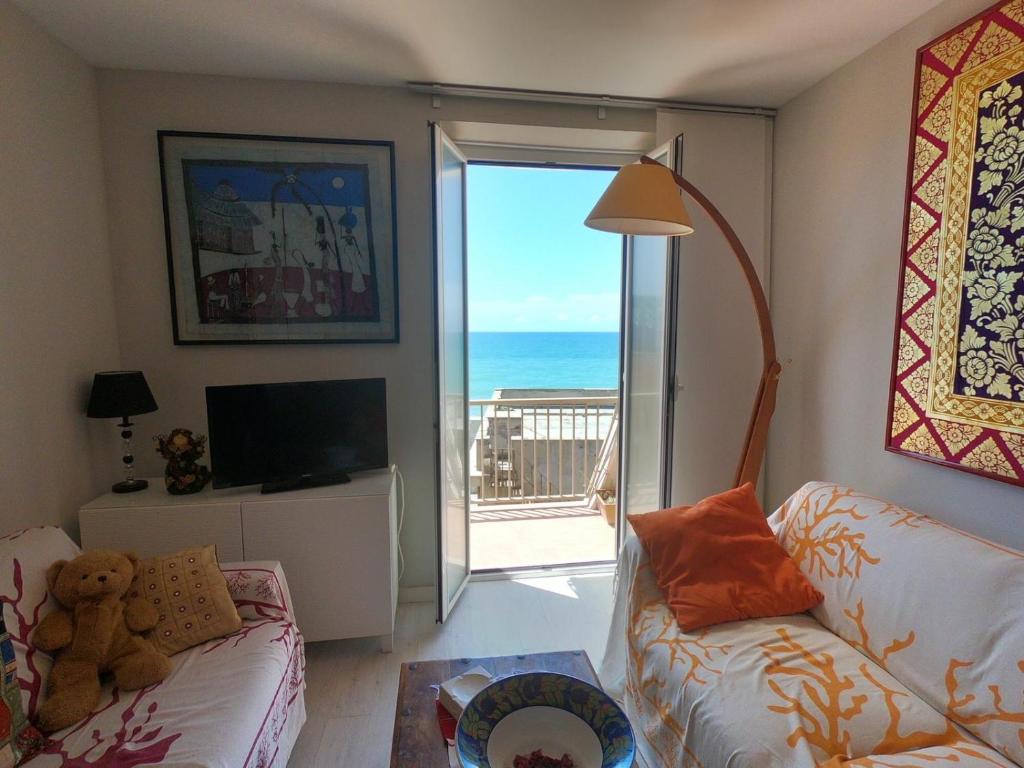 a living room with a couch and a view of the ocean at Rosso Tramonto luxury-white- LADISPOLI, Lungomare Regina Elena 58 in Ladispoli