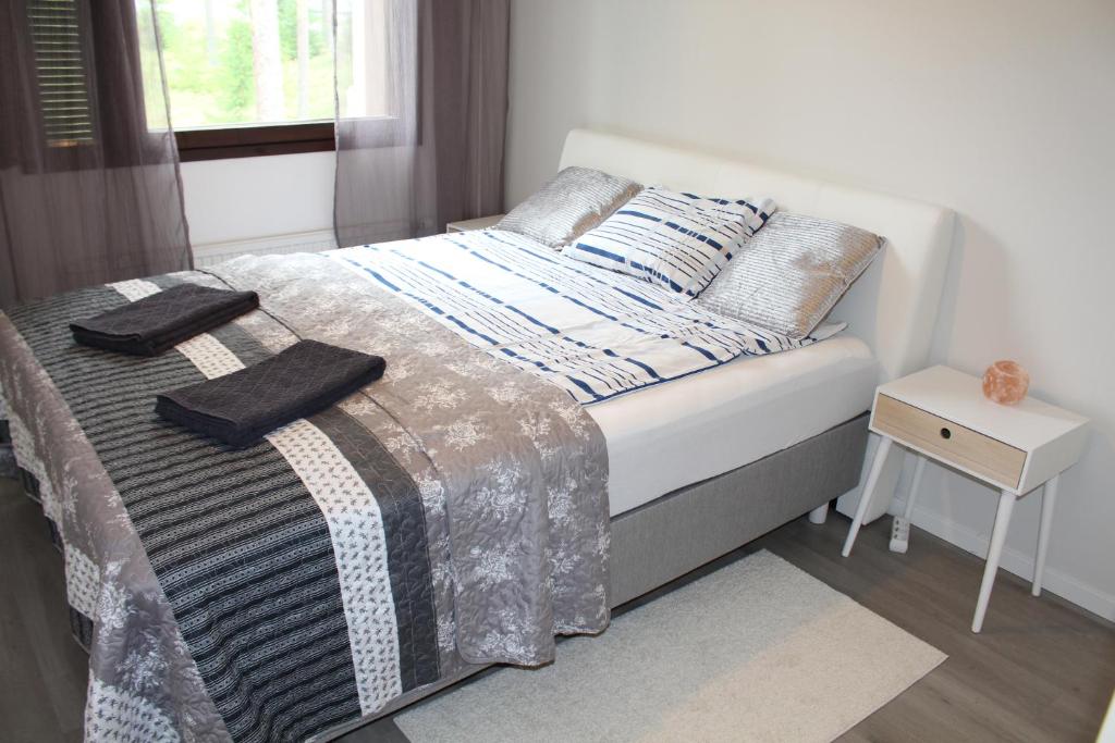 Una cama con manta y almohadas. en Bright star apartament Siilinjärvi, en Siilinjärvi