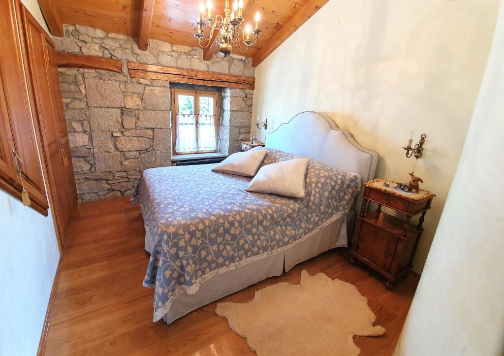 1 dormitorio con cama y pared de piedra en Casa Prodan, en Buzet