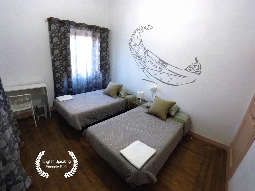 um quarto com duas camas e um mural de uma baleia em Aveiro Guest House em Aveiro