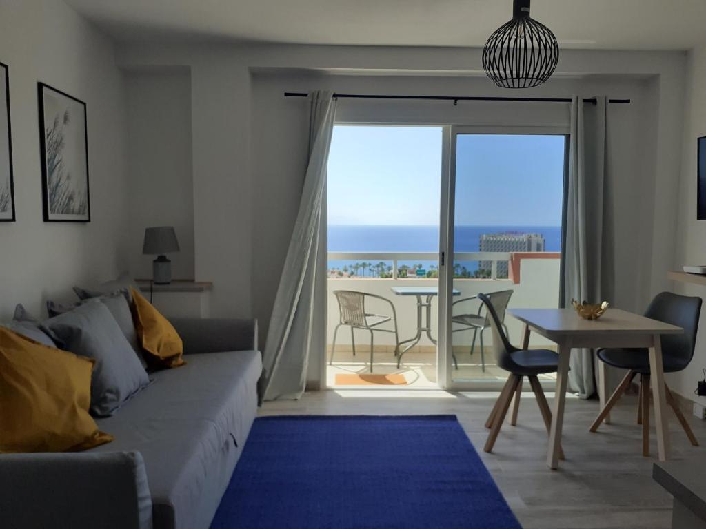 een woonkamer met een bank en een tafel bij KC home abroad panoramic sea view in Playa de las Americas