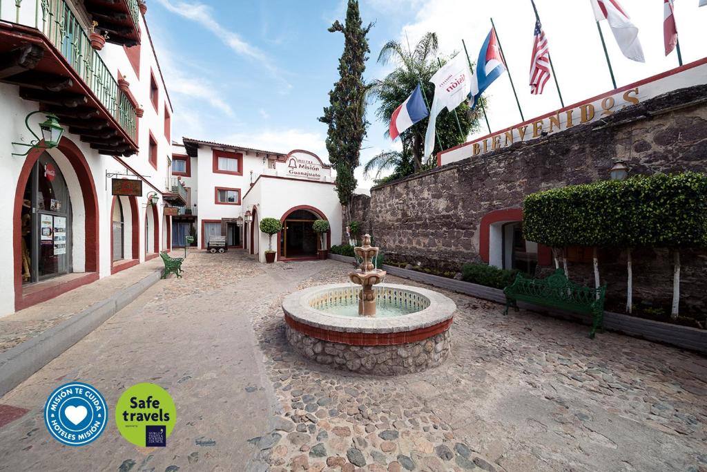 a fountain in the middle of a courtyard with flags at Mision Guanajuato in Guanajuato