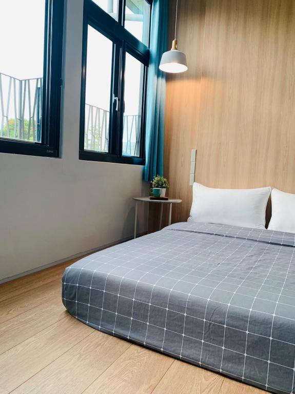 a bedroom with a large bed with a blue blanket at OYAJI Guesthouse 歐野基民家宿泊 in Tainan