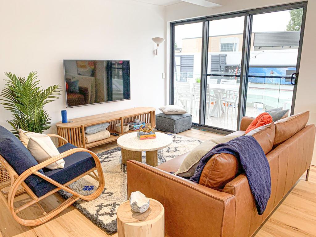 a living room with a couch and a table at Pavilions Collection in Airlie Beach