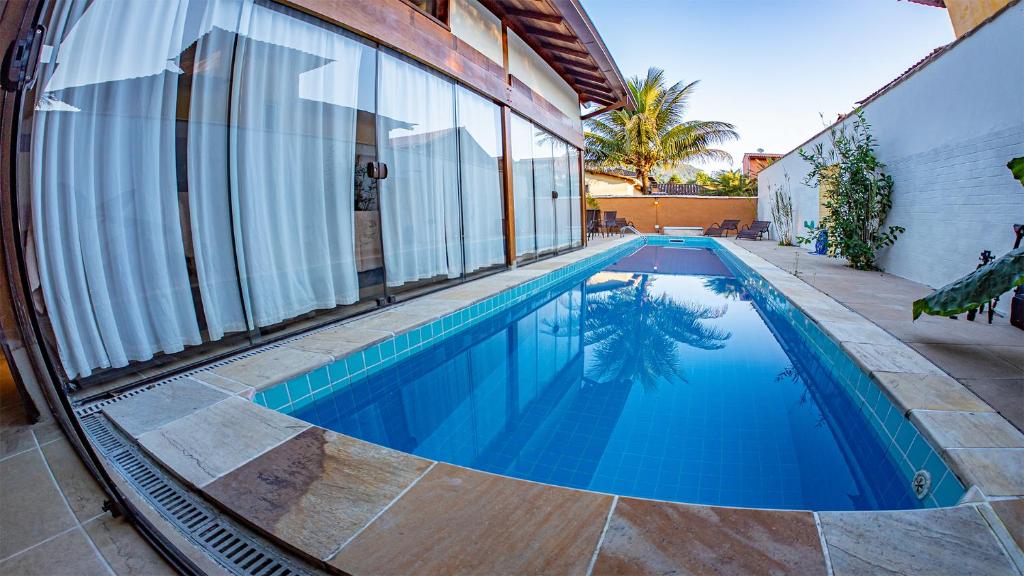 a swimming pool next to a house at Casa da Raia in Paraty