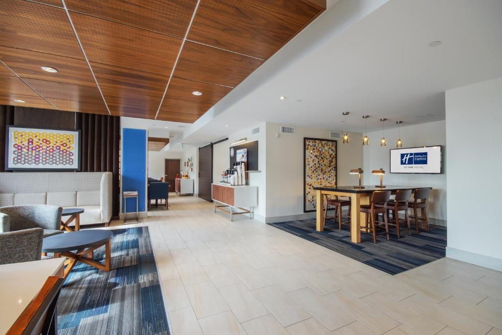 um lobby de um hospital com uma mesa e cadeiras em Holiday Inn Express Mira Mesa San Diego, an IHG Hotel em Mira Mesa