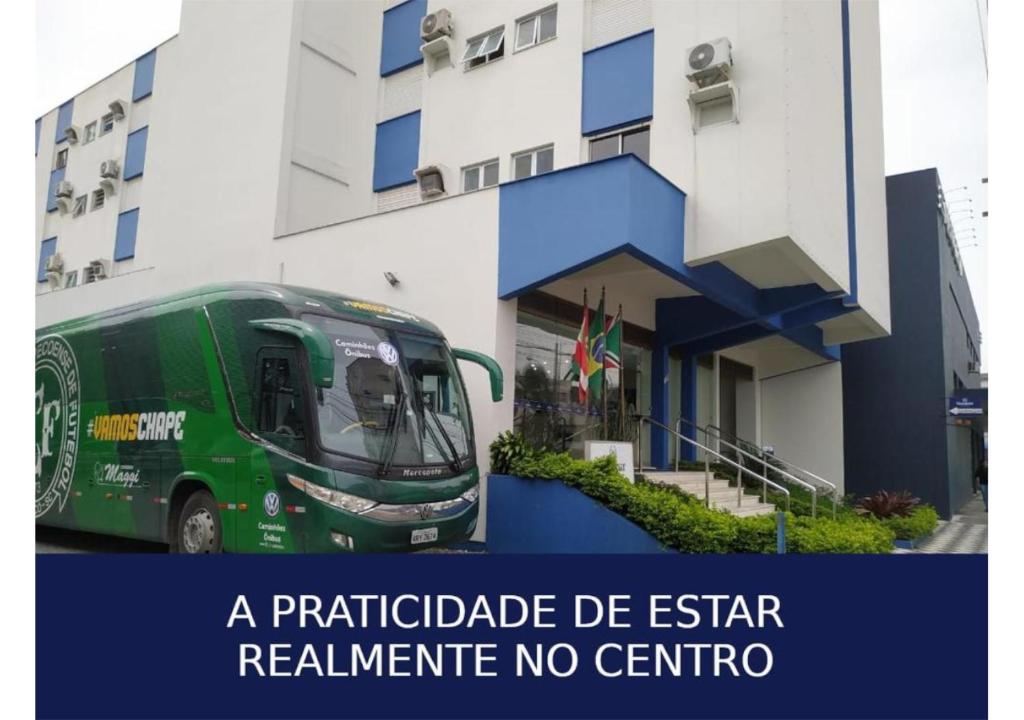 um autocarro verde estacionado em frente a um edifício em Soratur Hotel & Coworking em Criciúma