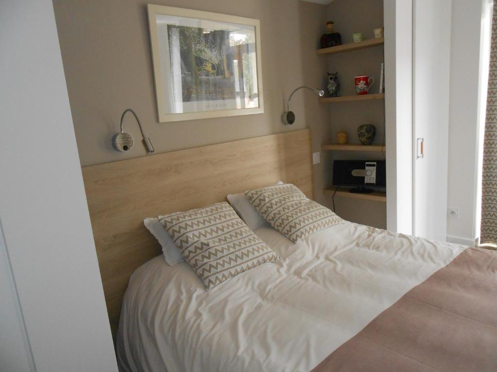 a bedroom with a bed with two pillows on it at chambre hôte avec piscine - La Vialatte in Gaillac